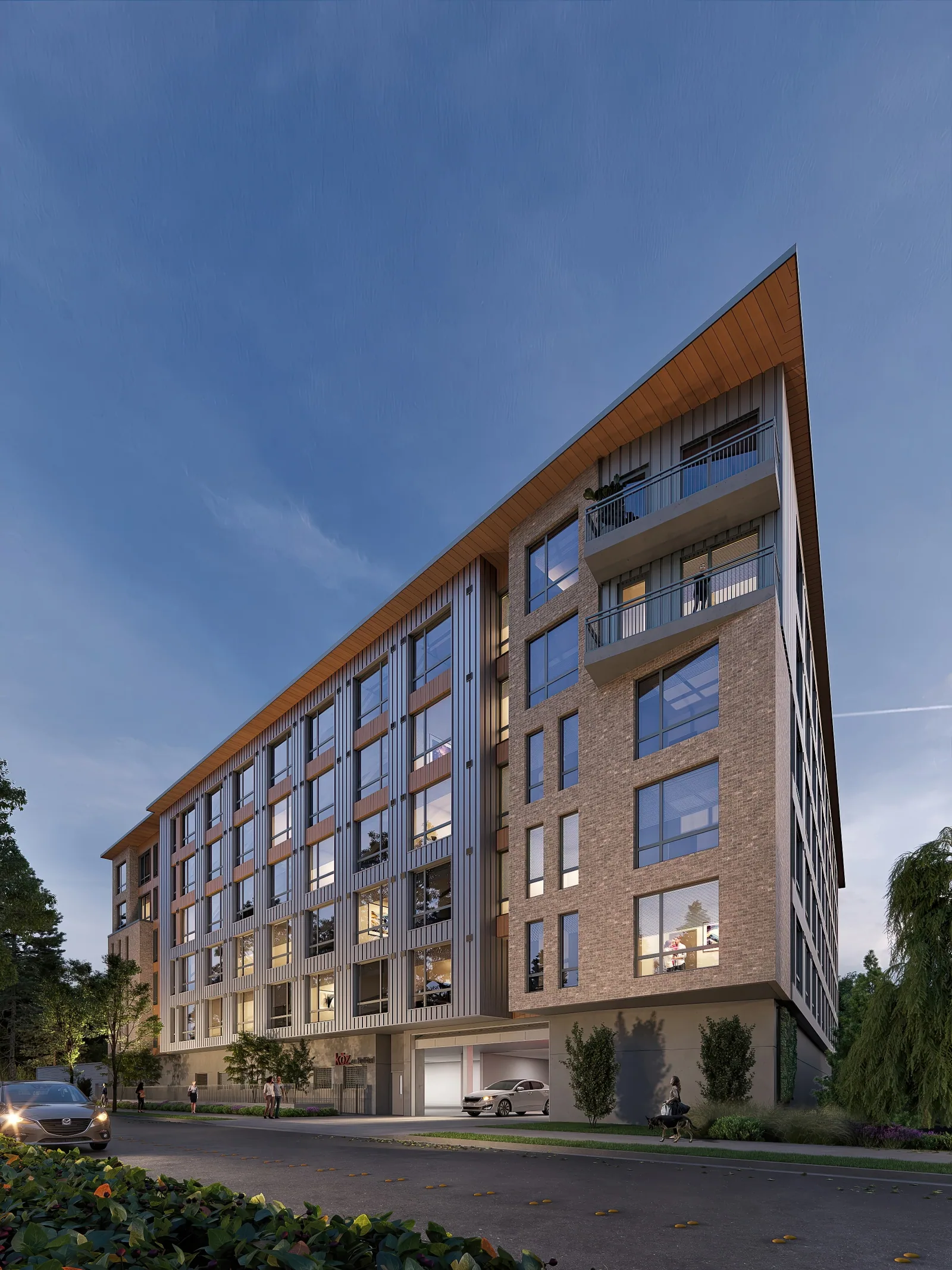 Brick mid-rise apartment building at Koz on BelRed in Bellevue at dusk with a wood-lined corner roof