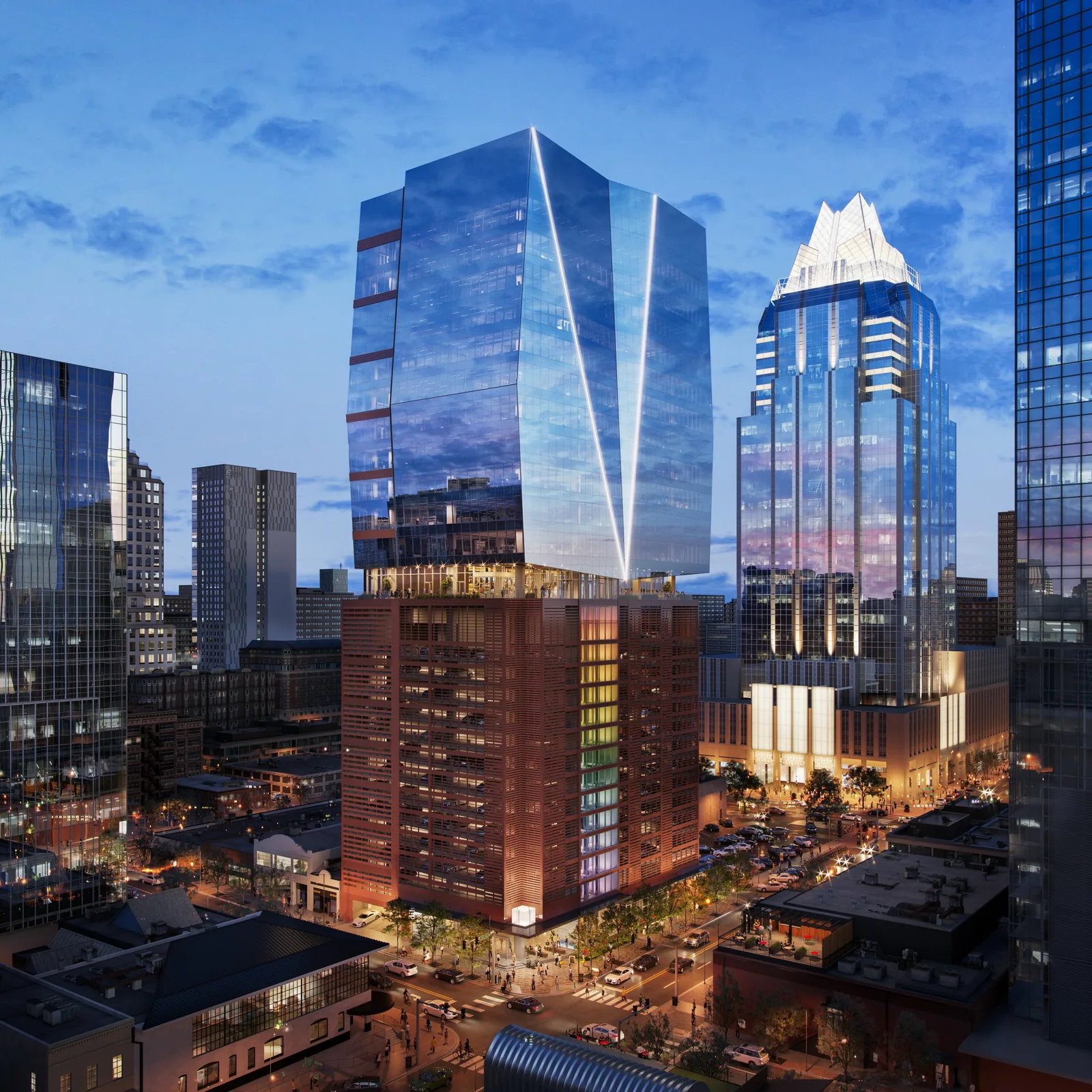 Faceted glass office tower at 405 Colorado in downtown Austin at dusk beside the Frost Bank Tower