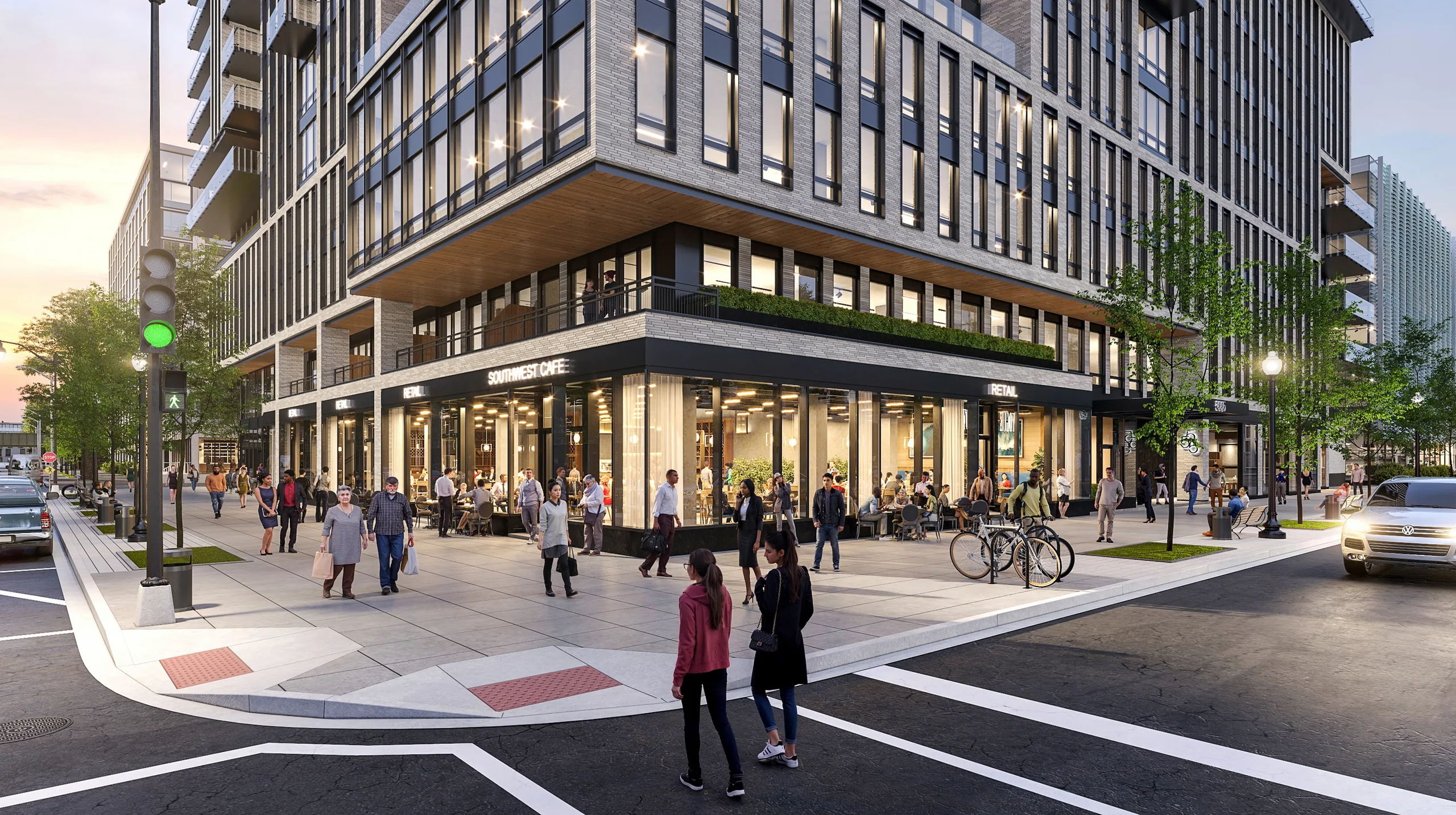 555 E Street SW in Washington, D.C., at dusk with busy ground-floor shops on a street corner