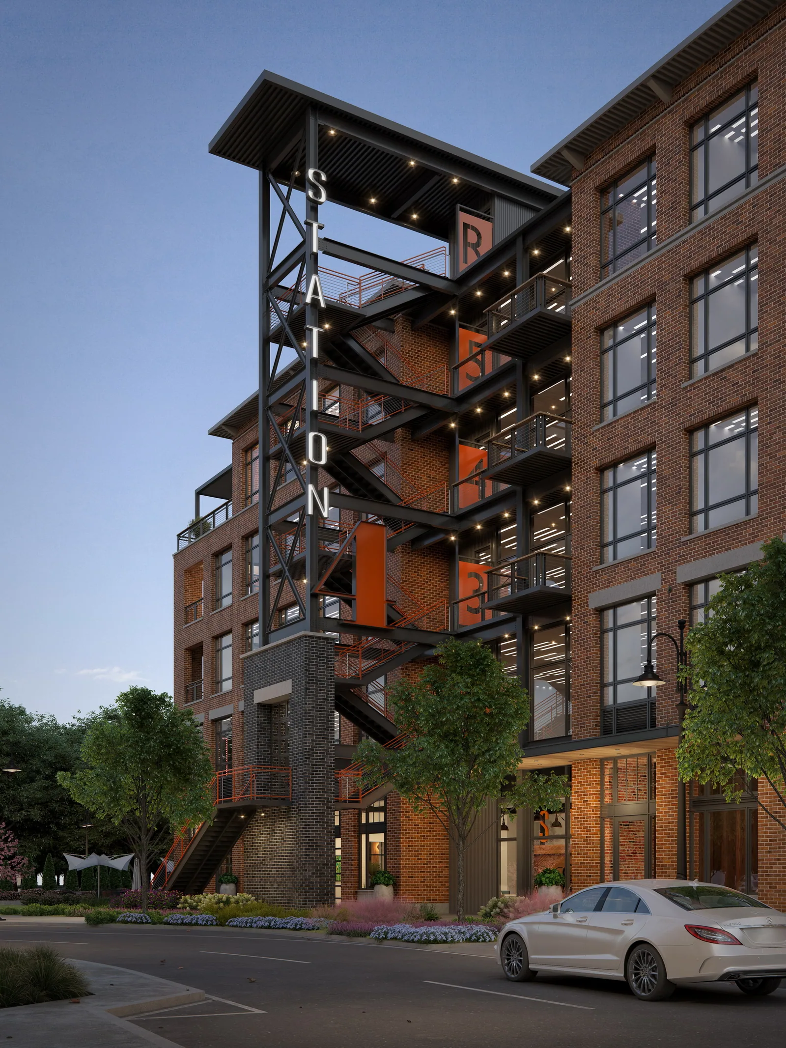 Brick office building with steel signage tower at The Station at LoSo, Charlotte, at dusk