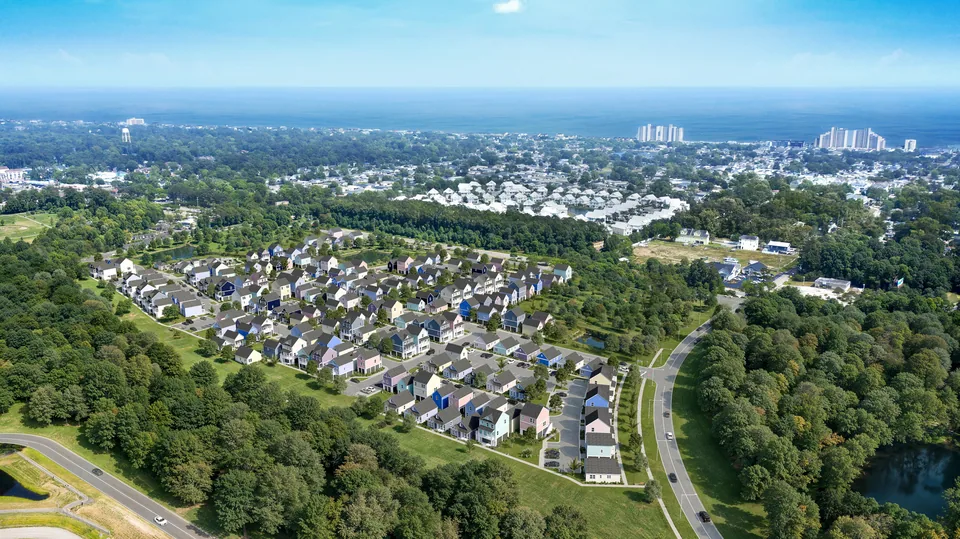 Aerial of the Swells Cottages community among woods with the ocean beyond, Garden City, SC