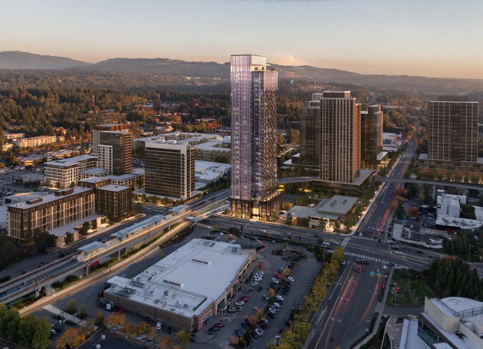 Aerial of the 11635 NE 8th St office tower rising over Bellevue at sunset with the foothills beyond
