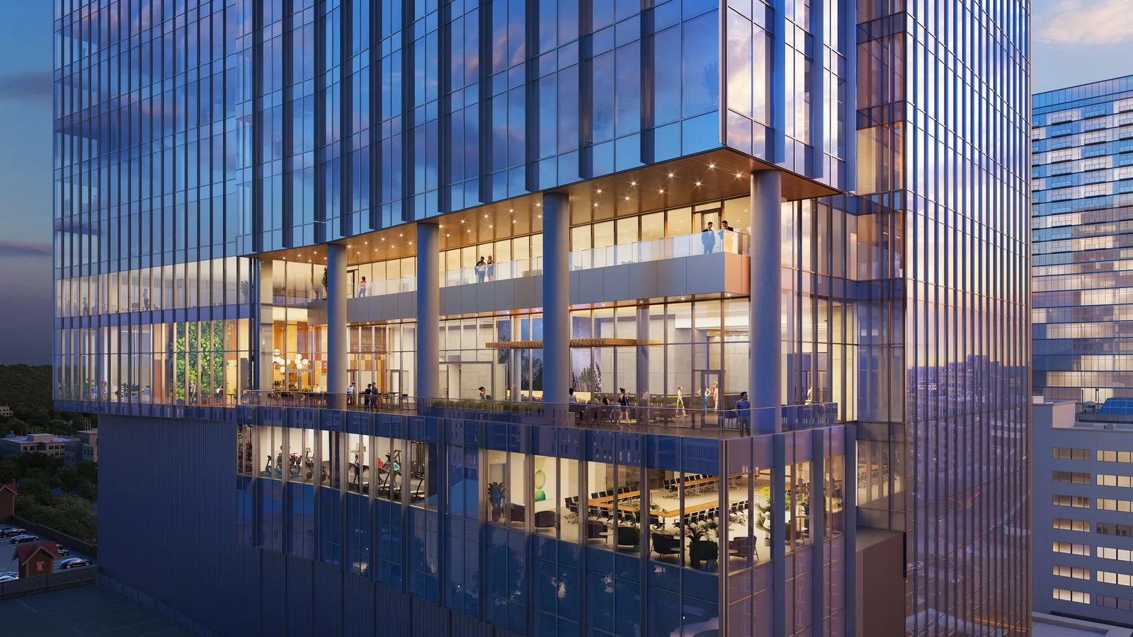 Glass amenity floors cantilevered over the street at 121 Fayetteville in downtown Raleigh at dusk