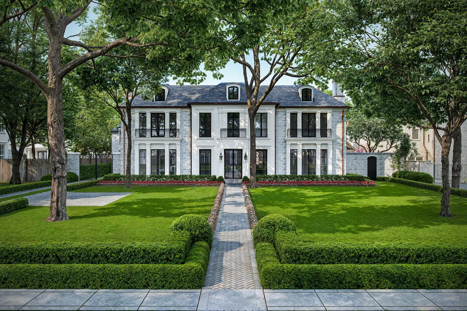 Formal front lawn and stone walk leading to the white 3024 Del Monte home in Houston under oaks