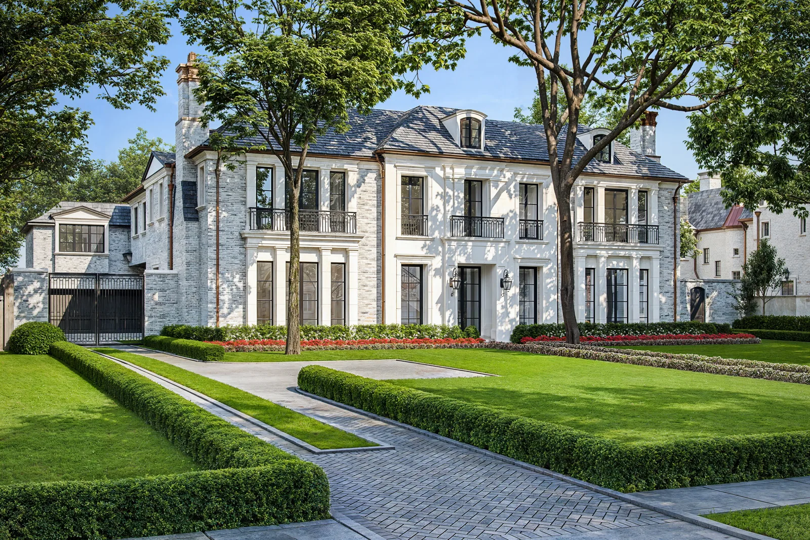White French-style home at 3024 Del Monte in Houston with slate mansard roof and clipped hedges