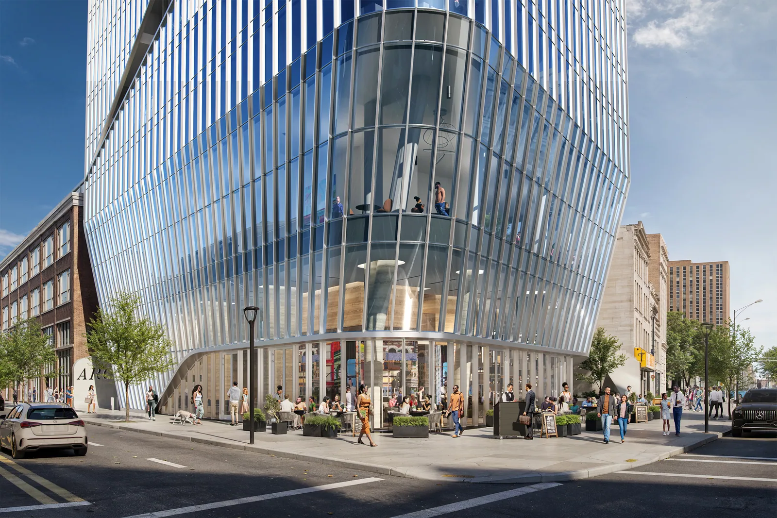 Curving finned glass base of Arc Tower at 571 Broad Street in Newark with a busy street cafe