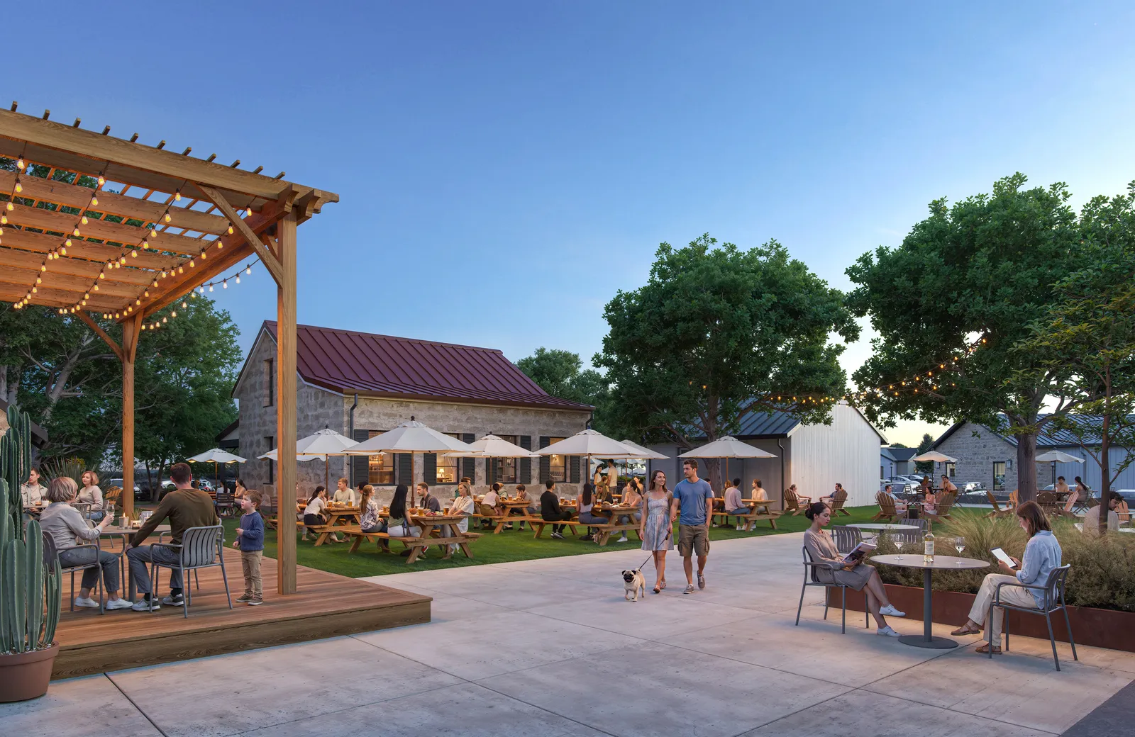 Pergola deck, picnic tables and stone restaurant buildings at Courtyard in the evening