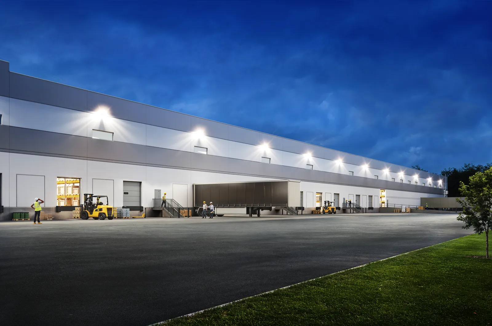 Lit loading docks and forklifts along a warehouse at Carolina Corridor Industrial Center at dusk
