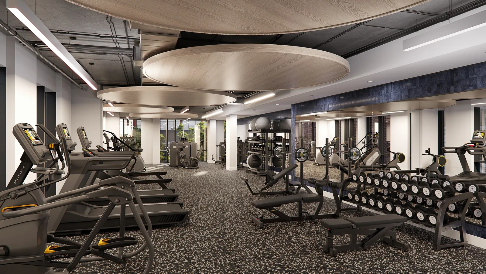 Fitness center with cardio machines, free weights and circular ceiling panels at The Gantry, D.C.