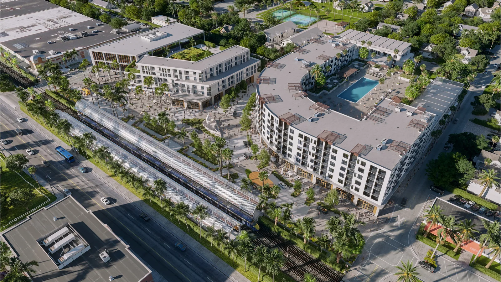 Aerial of the Sky Building mixed-use project with pool courtyard beside the rail line in Oakland Park, Florida
