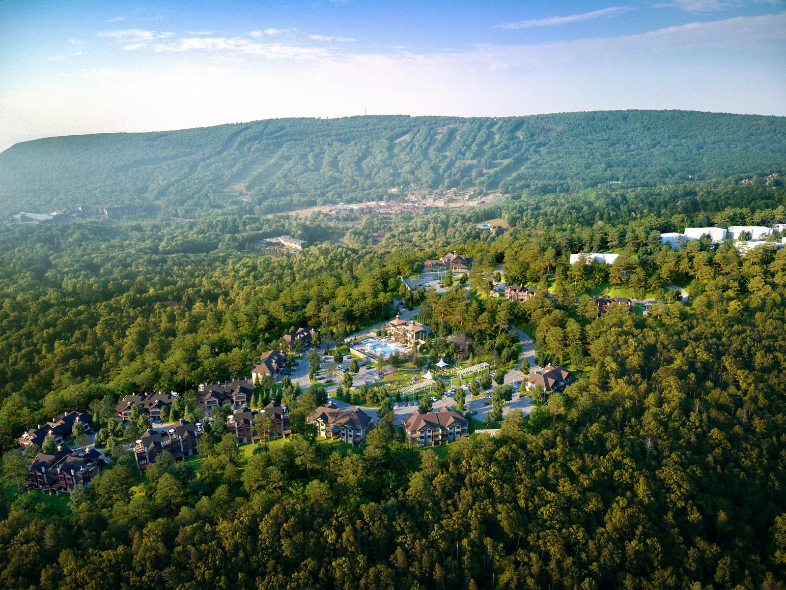 Aerial of resort lodges among forest below ski slopes in Tannersville, Pennsylvania, at sunset