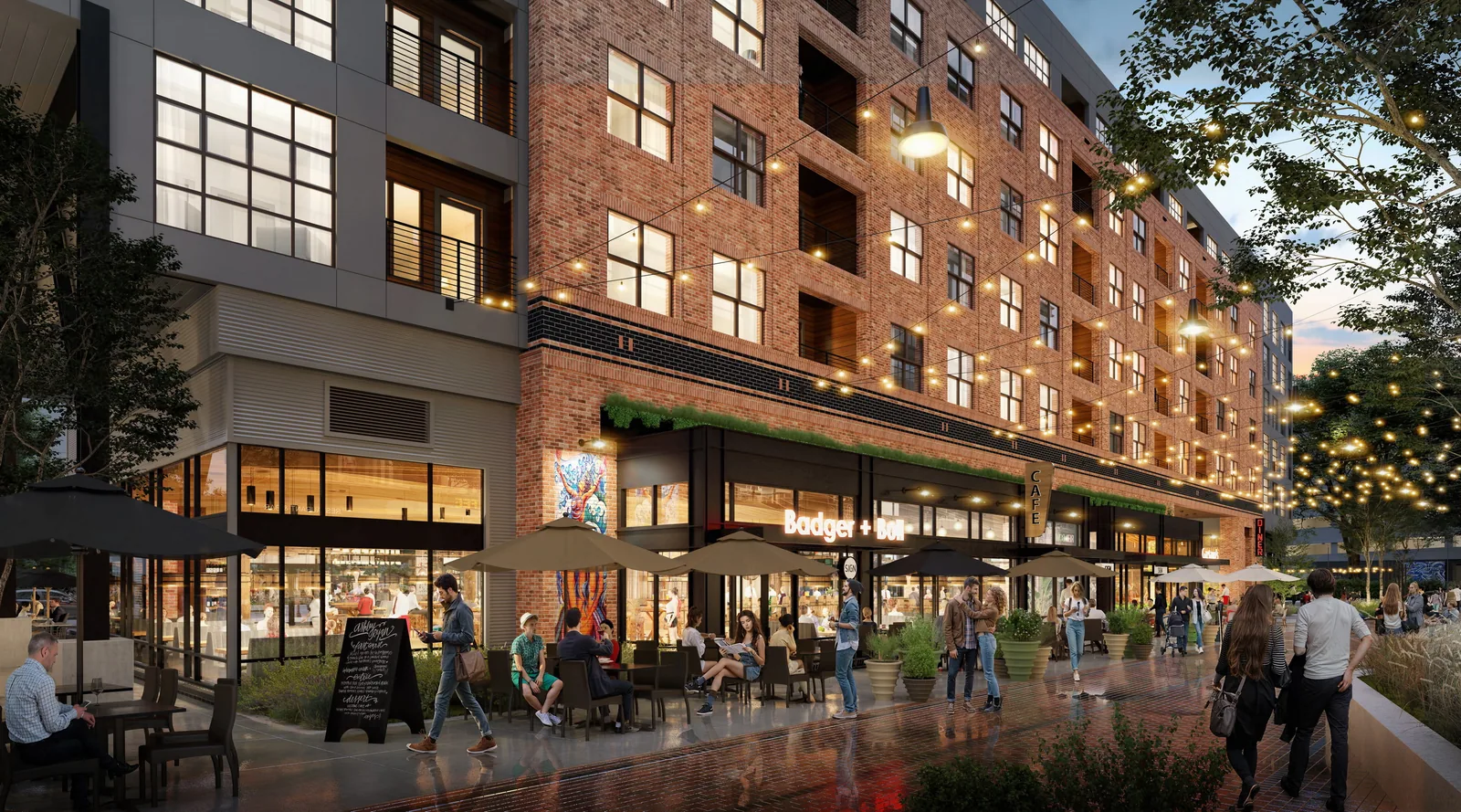 Shops and outdoor dining beneath brick apartments at The Line in Raleigh at dusk