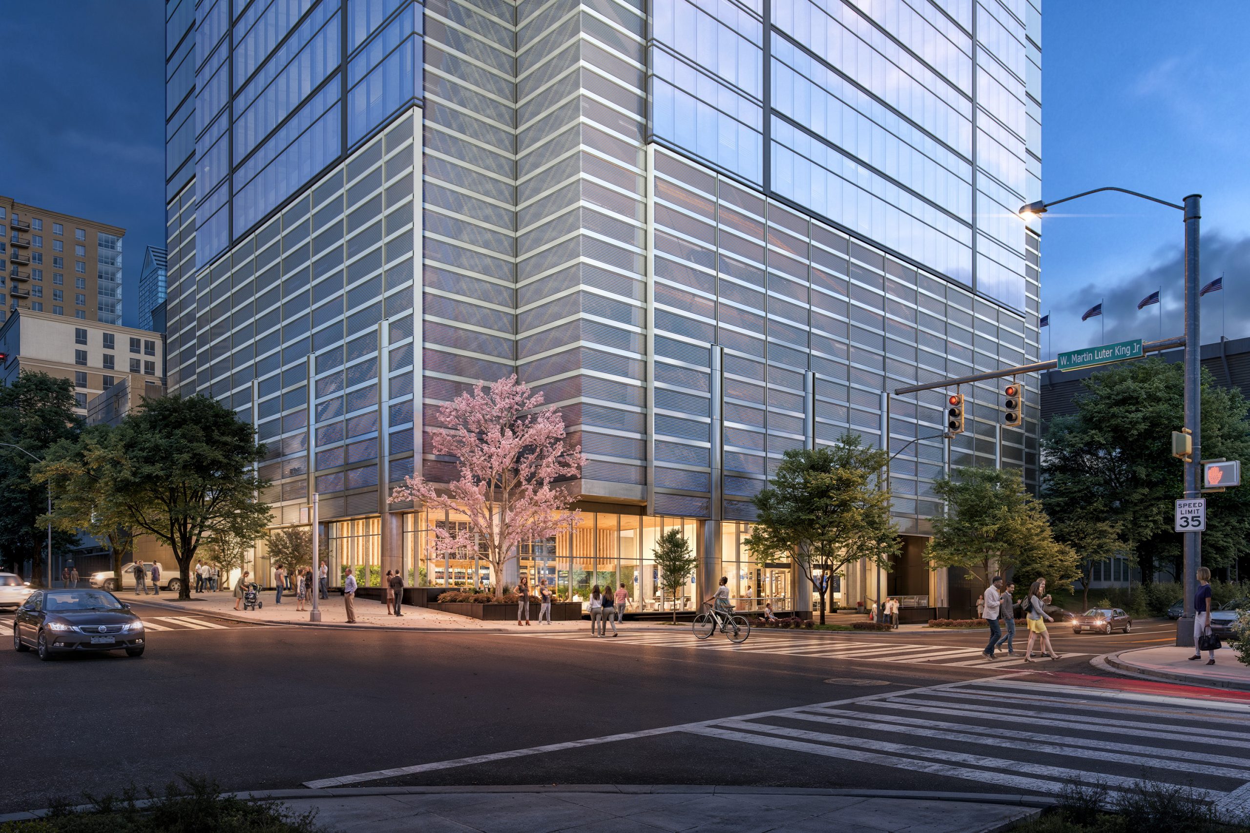 FNB Tower 401 South Graham Charlotte street-level exterior rendering by Bogza.com. A stunning twilight corner view of the luxury high-rise at Martin Luther King Jr. Boulevard, showcasing the illuminated ground-floor lobby and retail spaces, an angled glass curtain wall, a pink blooming tree, and active city pedestrians.