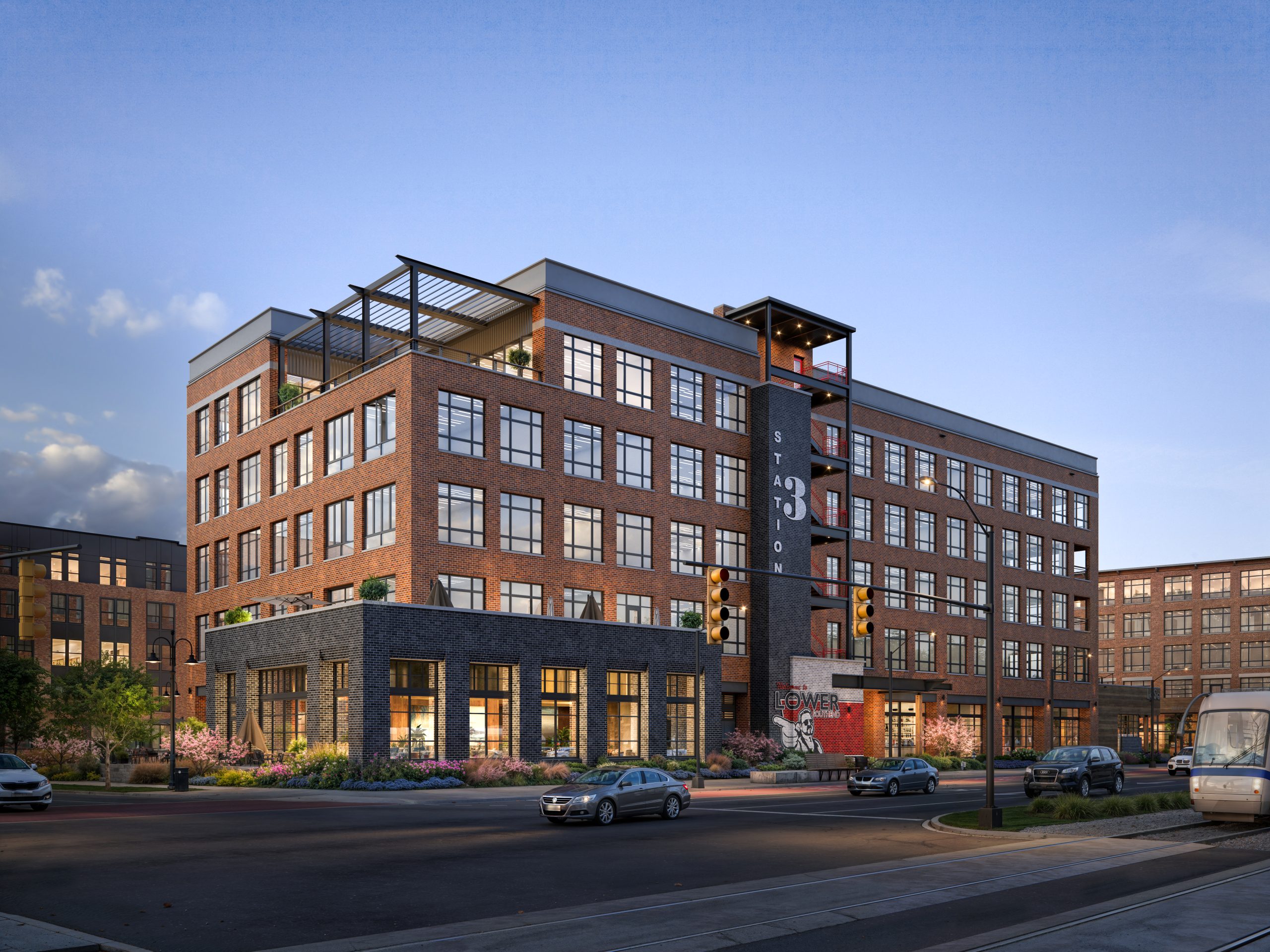 Station 3 at The Station at LoSo Charlotte architectural exterior rendering by Bogza.com. A twilight corner view of the luxury creative office building in Lower South End, featuring a red brick facade, expansive glass windows, and a prominent