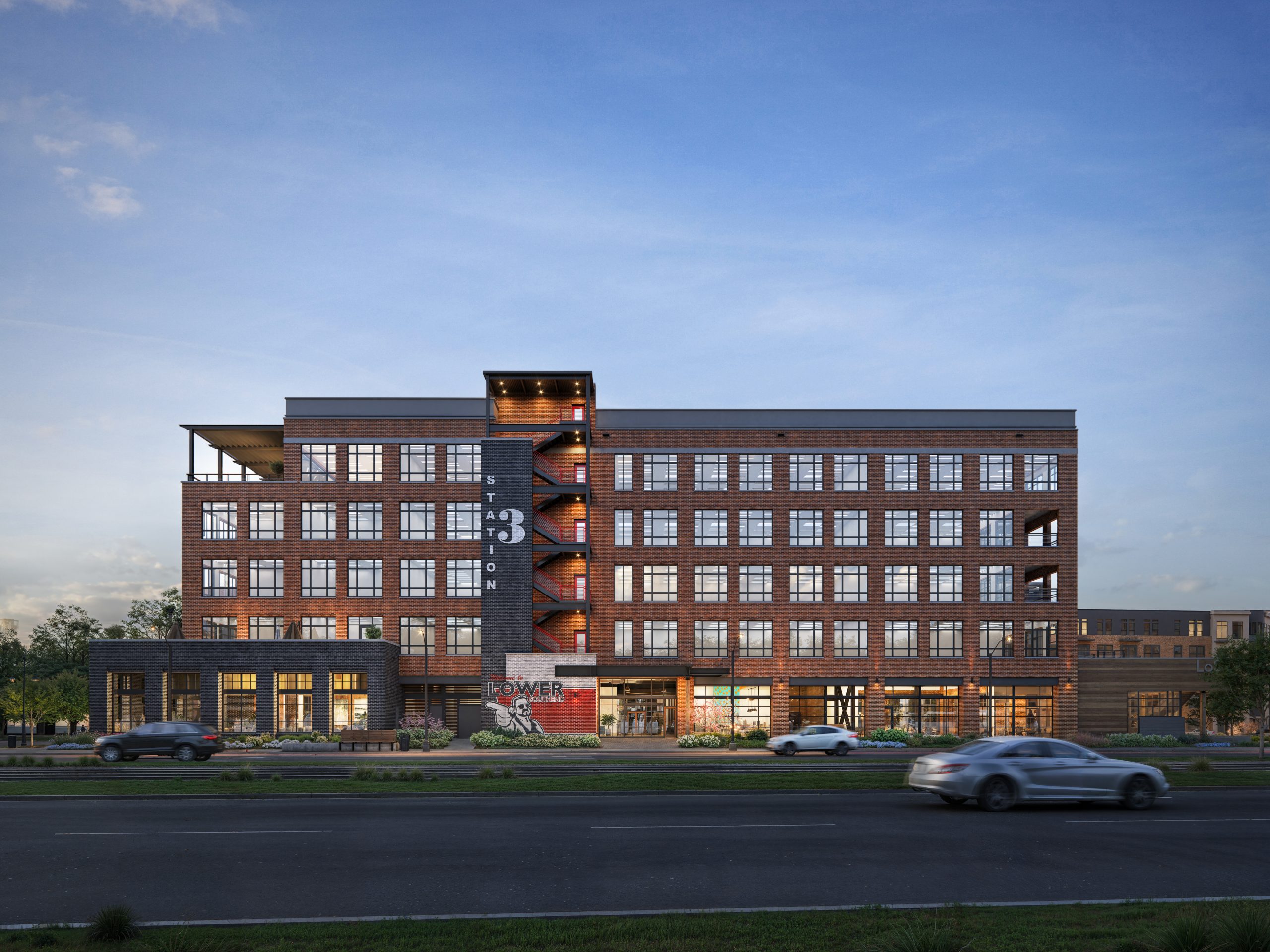 The Station at LoSo Charlotte creative office exterior rendering by Bogza.com. A bright daytime view of Station 3 in the Lower South End mixed-use development, showcasing the building's industrial-inspired red brick and metal facade, expansive windows, and the signature