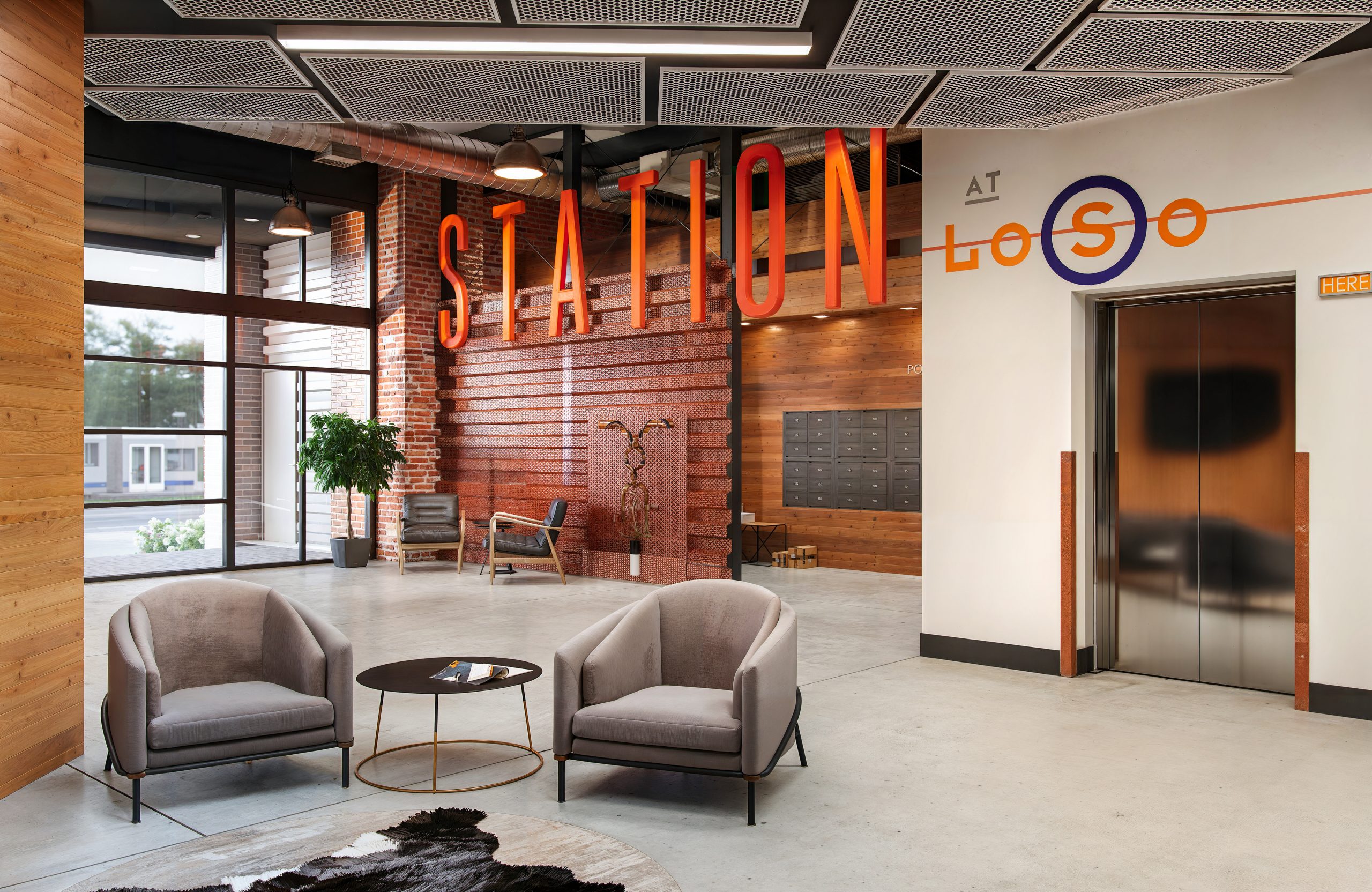 Station 3 at The Station at LoSo Charlotte office reception rendering by Bogza.com. A stylish industrial lobby featuring a massive