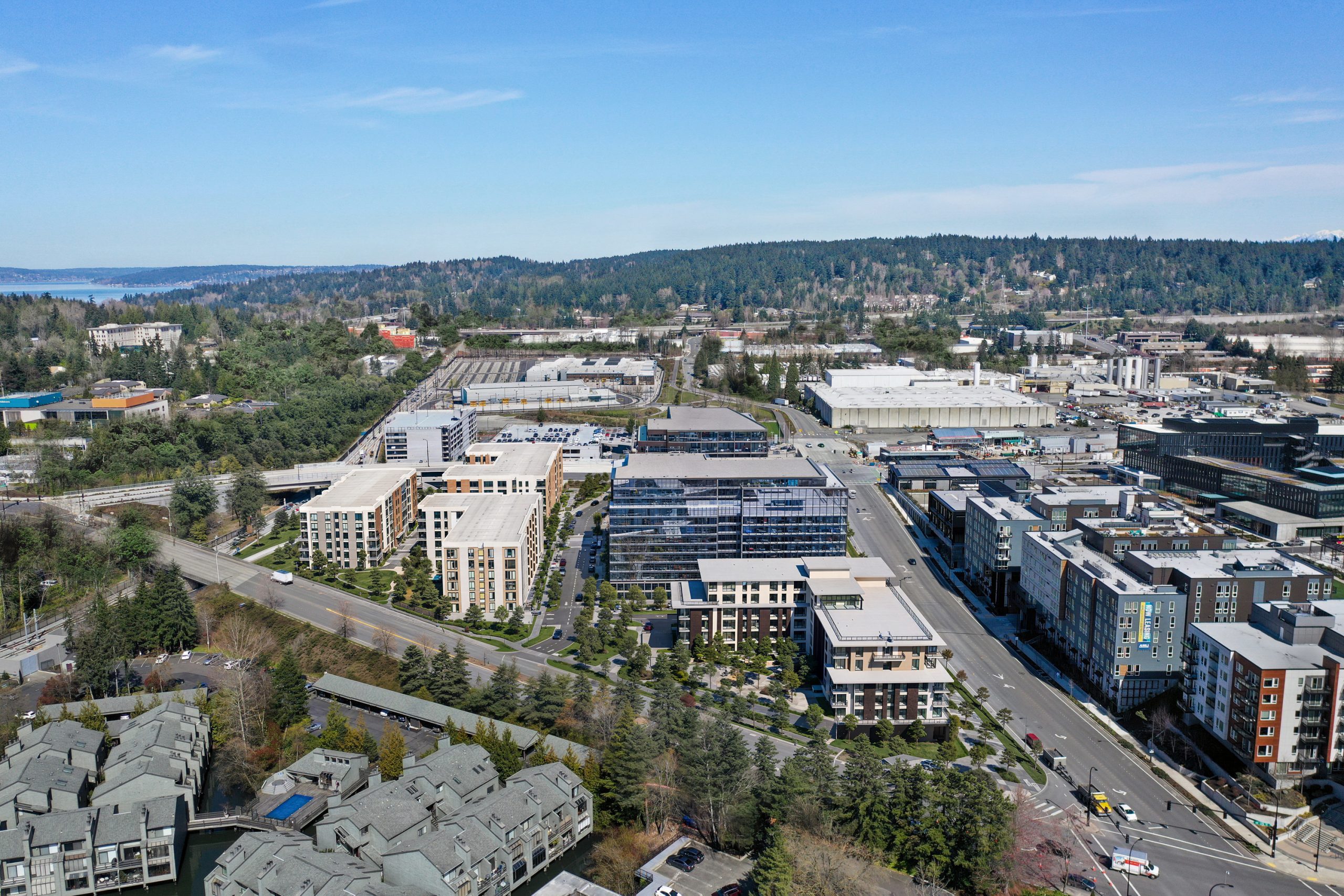 12th Place Development Bellevue high-angle aerial rendering by Bogza.com. A wide master plan view in the Bel-Red corridor highlighting a mix of residential apartments, sleek glass office structures, and surrounding neighborhood infrastructure.