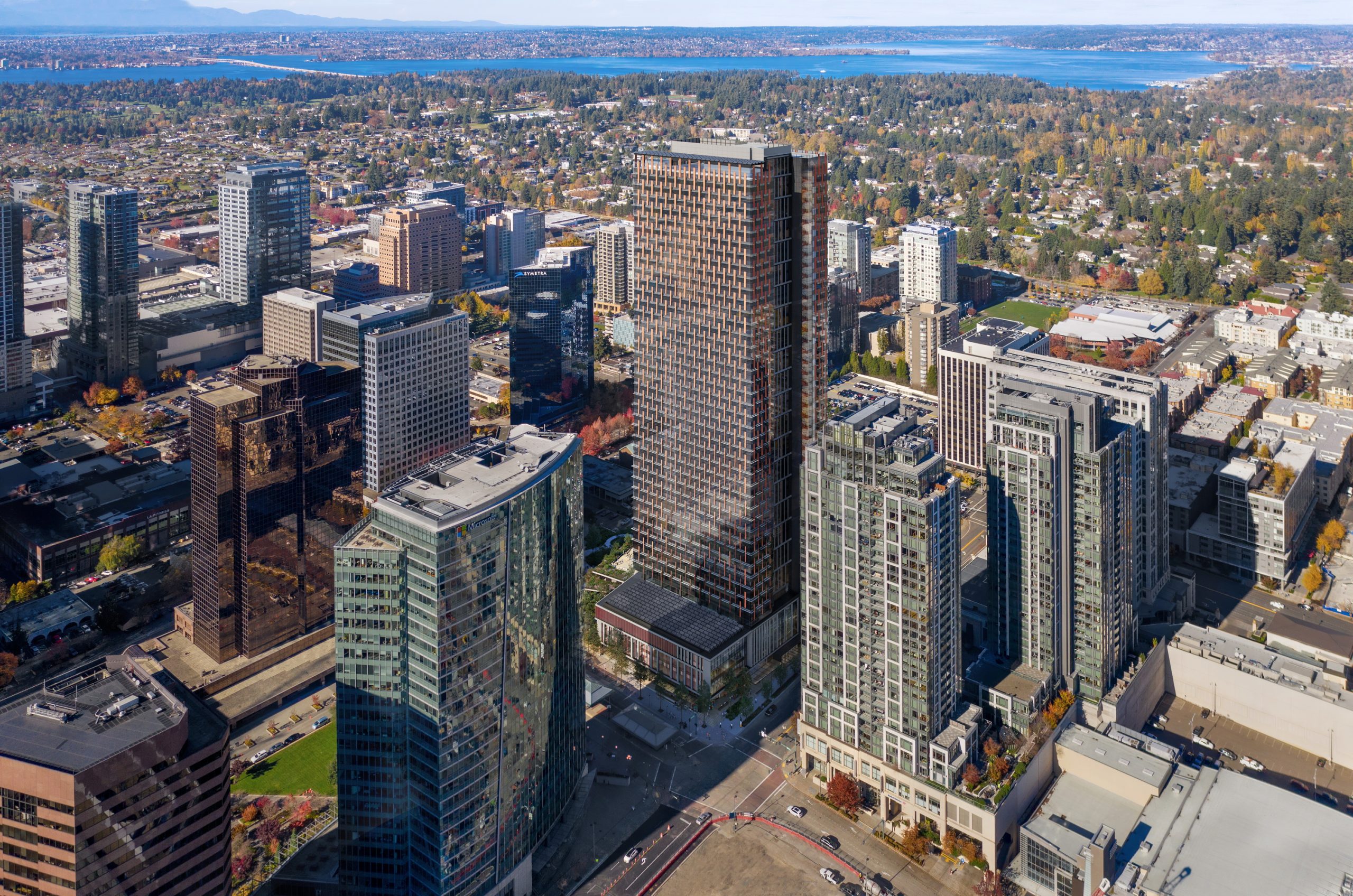 600 Bellevue daytime aerial architectural rendering by Bogza.com. A clear daytime view over the downtown skyline highlighting the 31-story glass office tower nestled among neighboring high-rises and urban infrastructure.