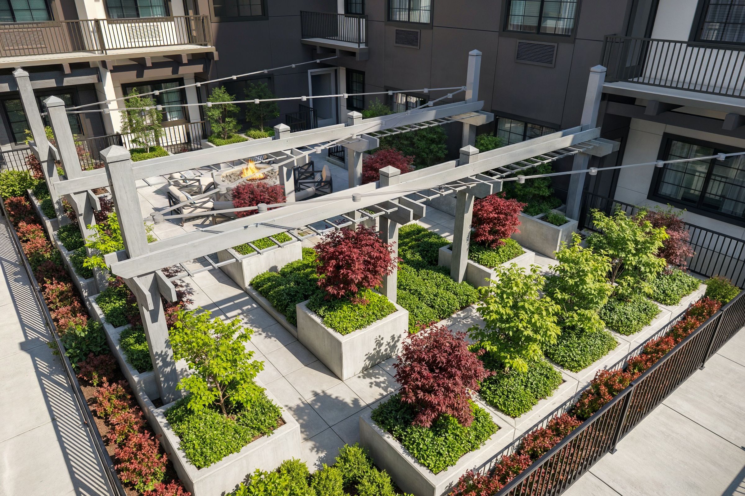 Bellevue Senior Living structured courtyard aerial rendering by Bogza.com. A high-angle daytime view looking down at the landscaped terrace featuring modern wooden pergolas, geometric concrete planters, a central fire pit, and lush greenery.