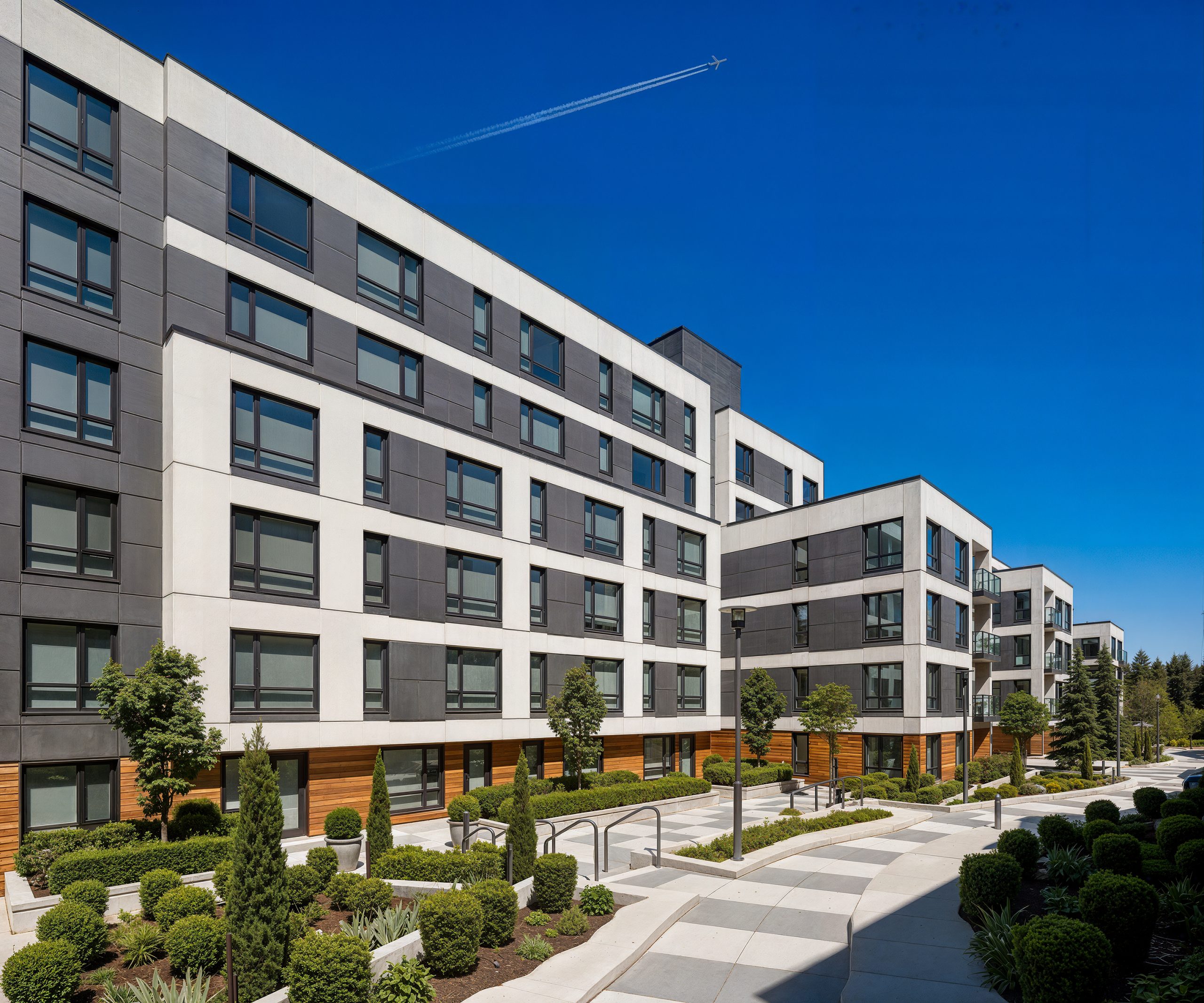 Hyde Square Bellevue apartments courtyard architectural rendering by Bogza.com. A daytime view of a beautifully landscaped pedestrian pathway winding between the modern mid-rise residential buildings, highlighting the white and dark gray facade with warm wood ground-floor accents.