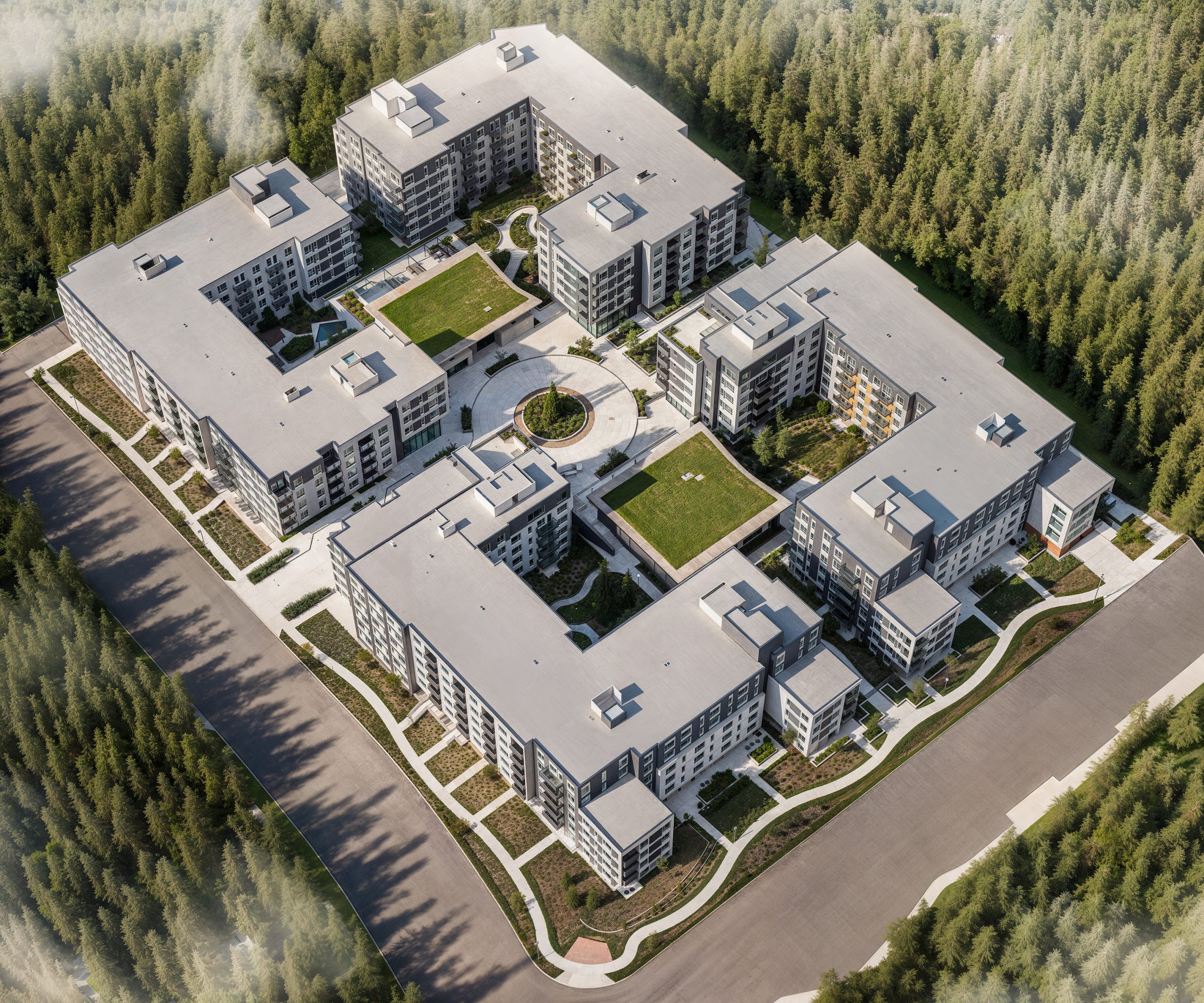 Hyde Square Bellevue aerial architectural rendering by Bogza.com. A high-angle bird's-eye view looking down at the expansive 618-unit luxury apartment community, showcasing the four connected mid-rise buildings, green living roofs, a central roundabout, and lush interior courtyards.