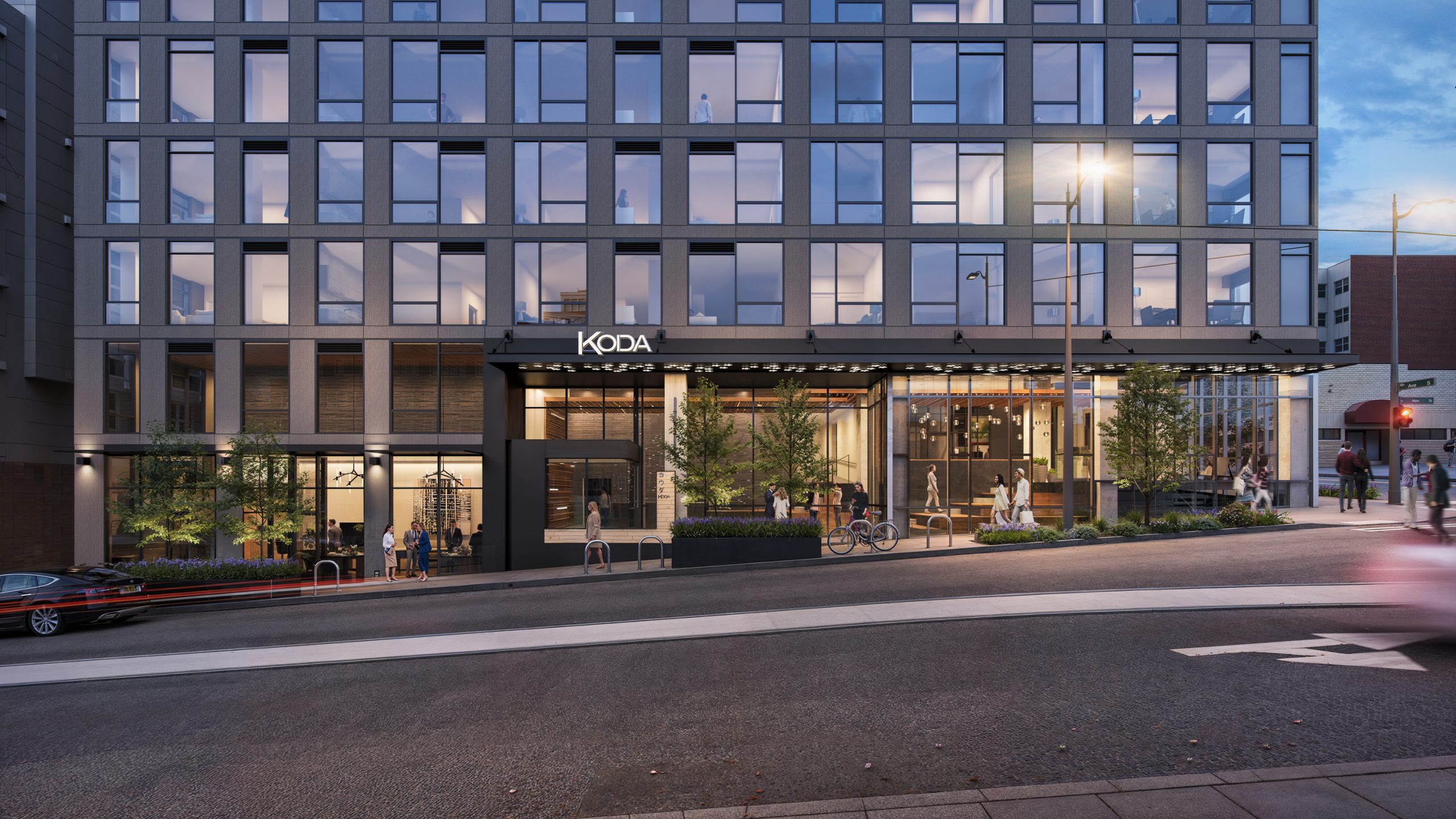 KODA Condominiums Seattle residential entrance architectural rendering by Bogza.com. A twilight view of the modern building's main lobby entrance and glowing marquee, showcasing expansive commercial storefronts, street planters, and a vibrant pedestrian streetscape in the International District.
