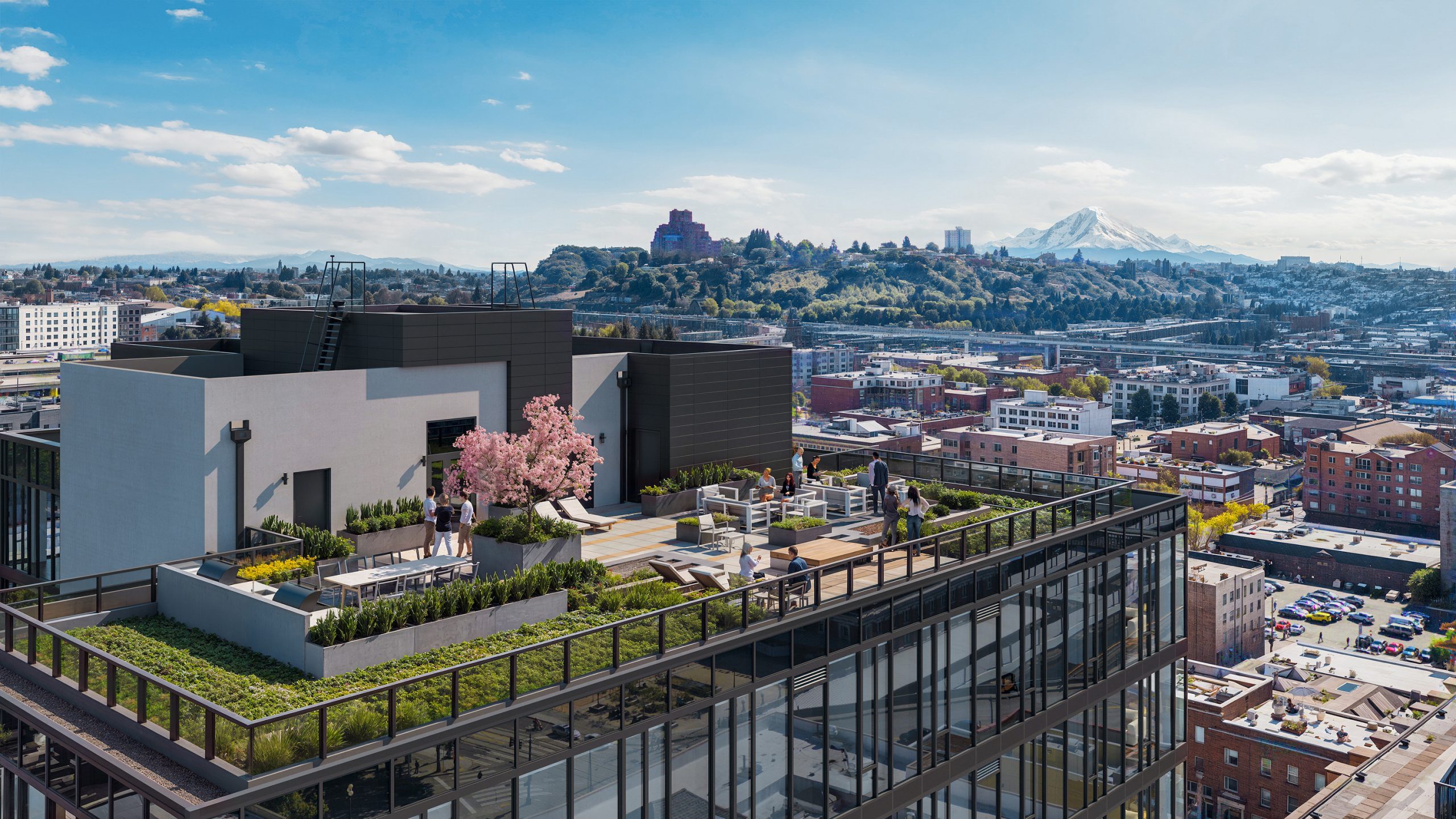 KODA Condos Seattle rooftop terrace amenity architectural rendering by Bogza.com. A high-angle daytime view of the luxury condominium's expansive outdoor sky park, featuring modern lounge seating, dining areas, lush green landscaping, and panoramic views stretching toward Mount Rainier.
