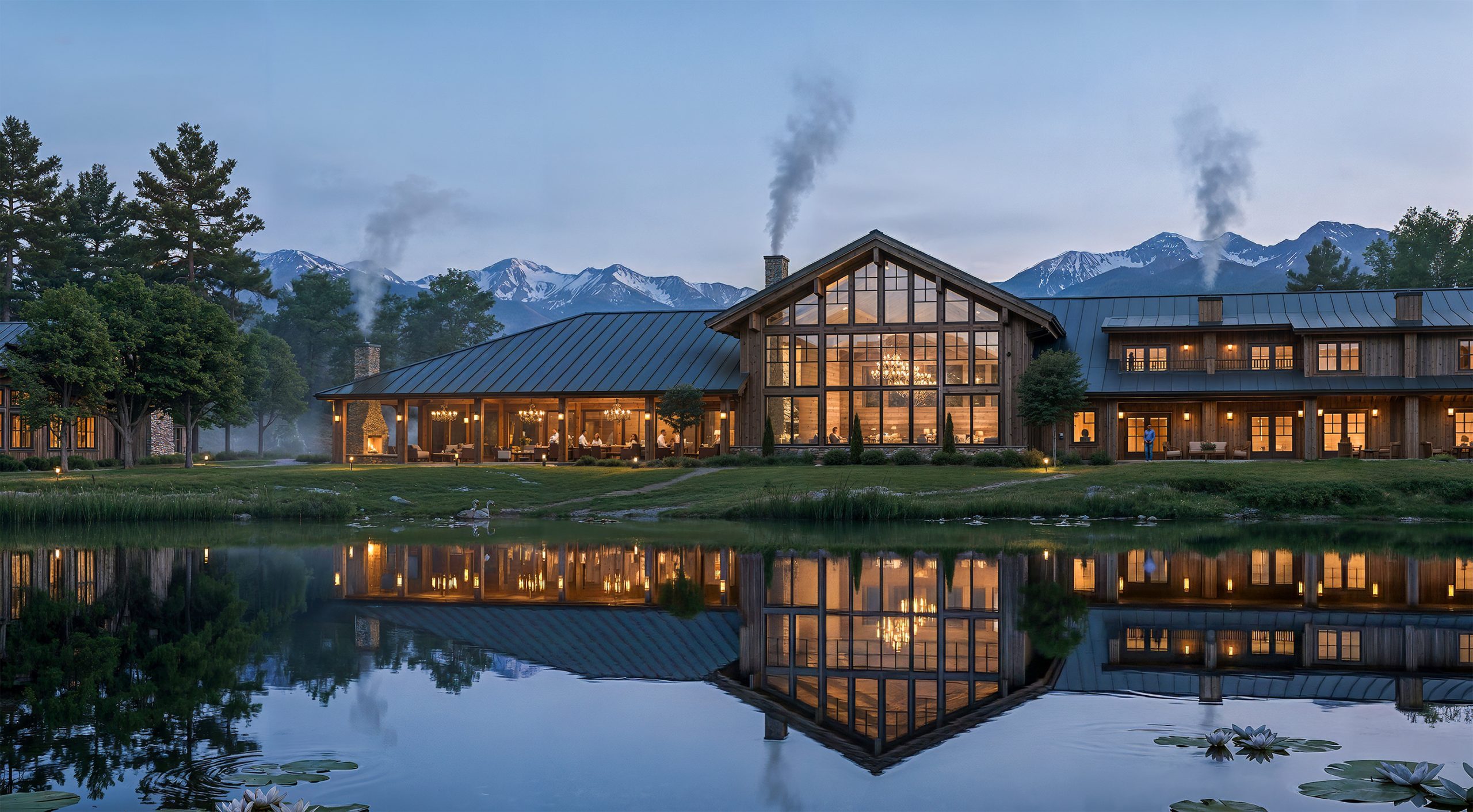 Sage Lodge Montana architectural exterior rendering by Bogza.com. A stunning twilight view of the main lodge reflecting beautifully in the serene casting pond, featuring glowing windows, active wood-burning stone chimneys, and the snow-capped Absaroka Mountains.