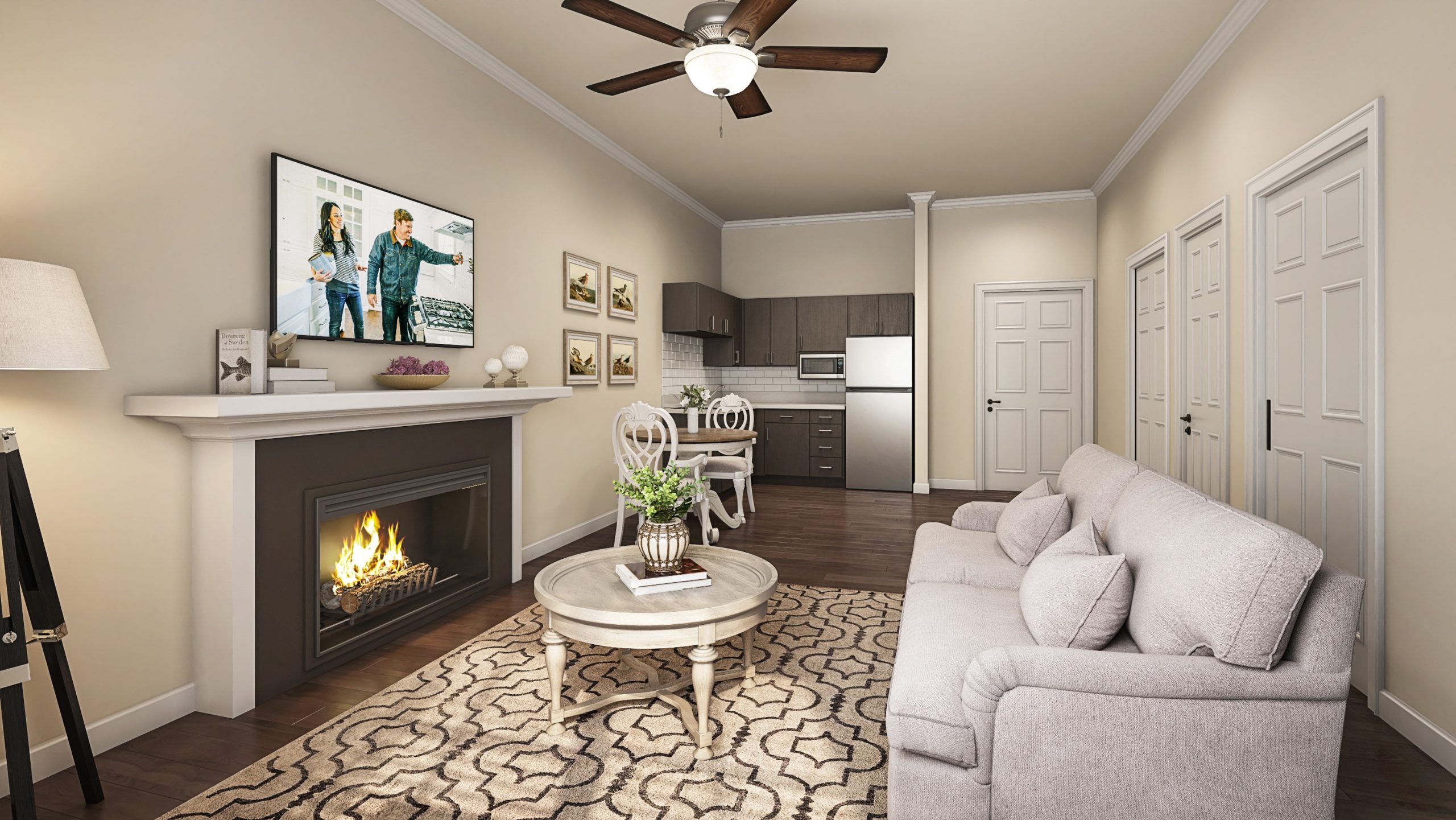 University Village retirement community private suite interior architectural rendering by Bogza.com. A bright, open-concept living space featuring a cozy lounge area with a fireplace, a small dining table, and a modern kitchenette with dark cabinetry.