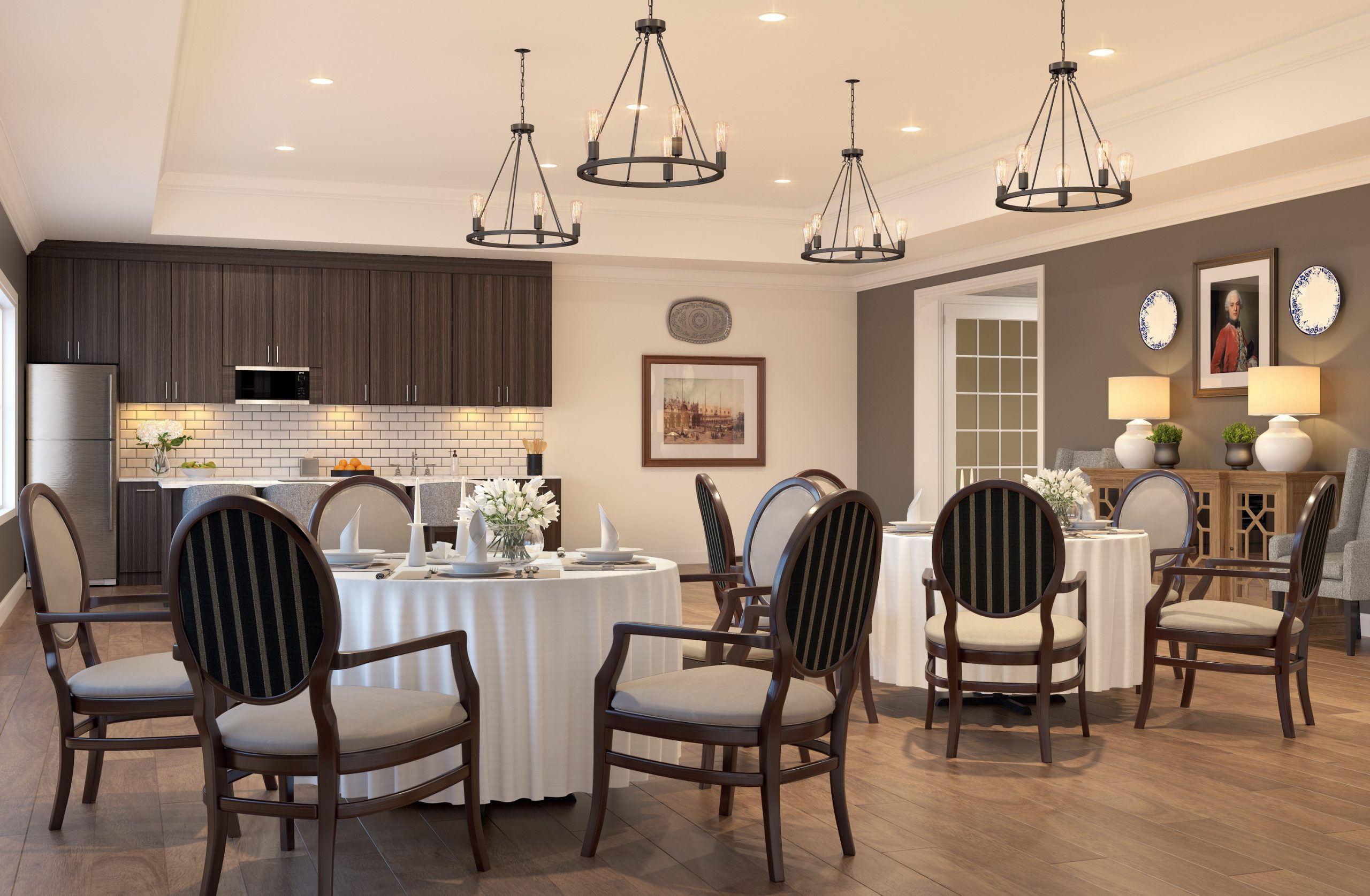 University Village senior living private dining room and kitchen interior rendering by Bogza.com. An intimate, elegant entertaining space featuring round dining tables, classic upholstered chairs, iron ring chandeliers, and an open-concept kitchen with a white subway tile backsplash.